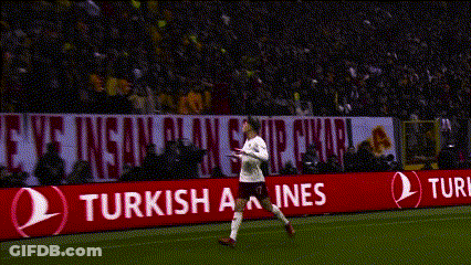 A Soccer Player Stands On The Field In Front Of A Banner That Says Enjoy Responsibly GIF