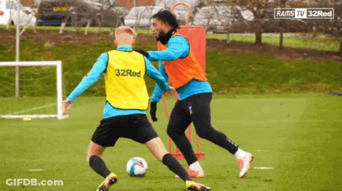 A Soccer Player Wearing A 32Red Vest Kicks A Ball GIF