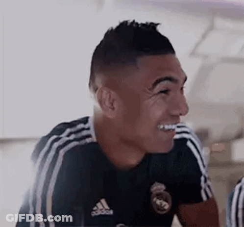A Soccer Player Wearing A Black Adidas Jersey Is Smiling . GIF