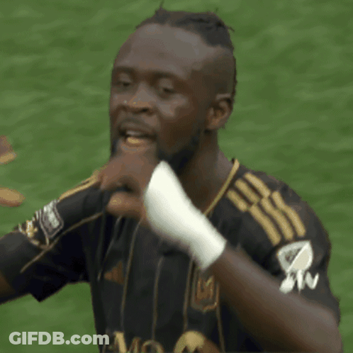 A Soccer Player Wearing A Black And Gold Jersey With The Letter M On It GIF