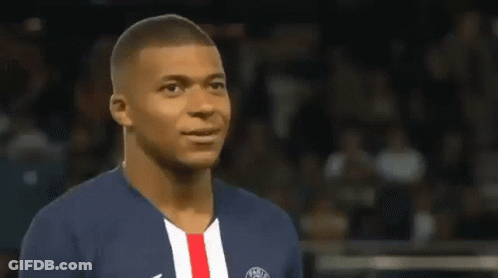 A Soccer Player Wearing A Blue And White Jersey With A Red And White Stripe On The Front Is Smiling . GIF