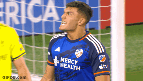 A Soccer Player Wearing A Blue Mercy Health Shirt GIF