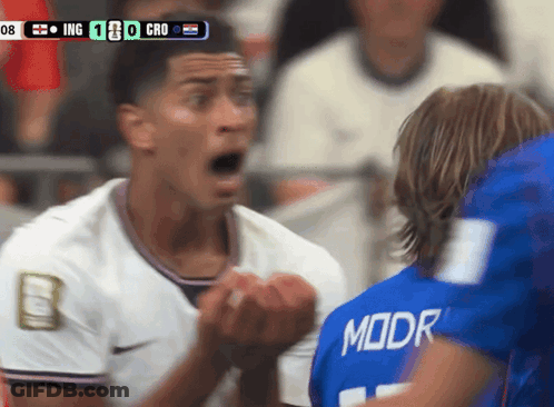A Soccer Player Wearing A Blue Moor Jersey Stands In Front Of Another Player GIF