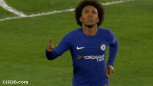 A Soccer Player Wearing A Blue Yokohama Jersey Points Upwards GIF