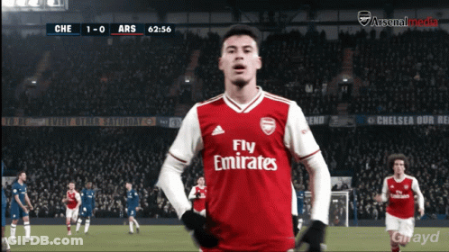 A Soccer Player Wearing A Fly Emirates Jersey Stands In Front Of A Crowd GIF