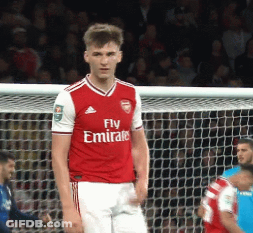 A Soccer Player Wearing A Fly Emirates Jersey Stands In Front Of A Net GIF