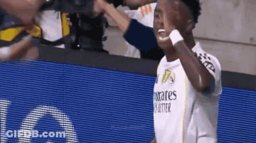 A Soccer Player Wearing A Fly Emirates Shirt Is Giving A High Five To His Teammates . GIF