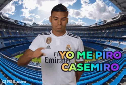 A Soccer Player Wearing A Fly Emirates Shirt Stands In Front Of A Stadium GIF