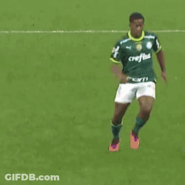 A Soccer Player Wearing A Green Jersey With The Word Caf On It Is Kicking Another Player GIF