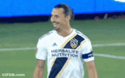 A Soccer Player Wearing A Herbalife Nutrition Jersey Smiles GIF