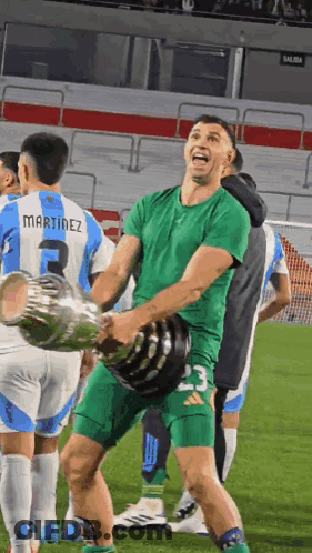 A Soccer Player Wearing A Martinez Jersey Holds A Trophy GIF