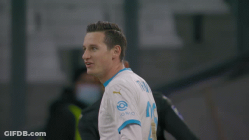 A Soccer Player Wearing A Medina 14 Jersey Stands Next To Another Player GIF