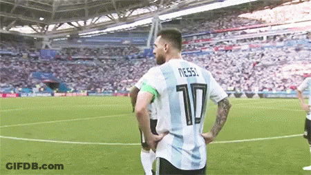A Soccer Player Wearing A Number 10 Jersey Is Standing On A Soccer Field With His Hands On His Hips . GIF