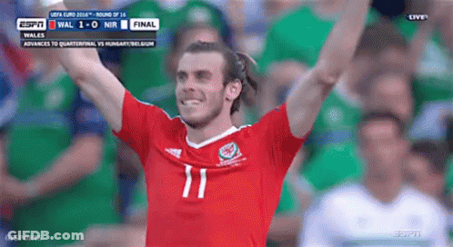 A Soccer Player Wearing A Number 11 Jersey Is Raising His Arms In The Air GIF