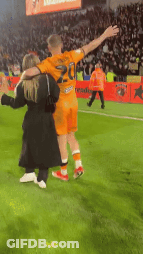 A Soccer Player Wearing A Number 20 Jersey Is Hugging A Woman GIF