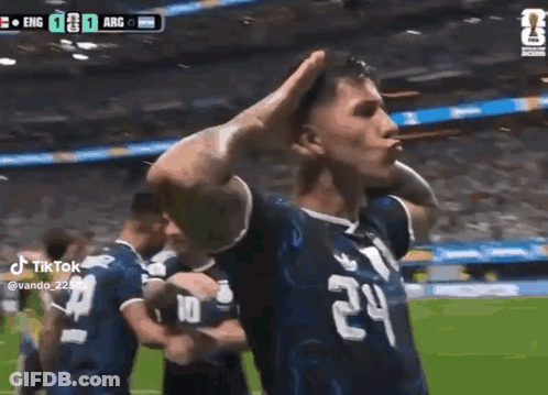 A Soccer Player Wearing A Number 24 Jersey Is Standing On A Field With His Hands On His Head . GIF