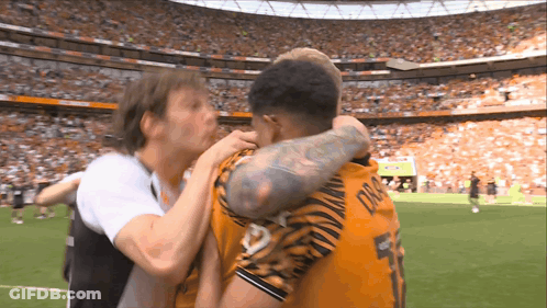 A Soccer Player Wearing A Number 5 Jersey Is Hugging Another Player GIF