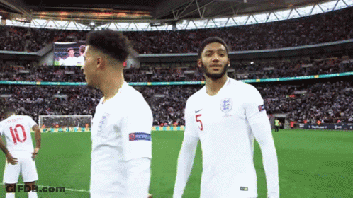 A Soccer Player Wearing A Number 5 Jersey Stands Next To Another Player Wearing A Number 10 Jersey GIF