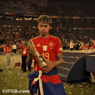 A Soccer Player Wearing A Qatar Airways Jersey Is Holding A Trophy GIF