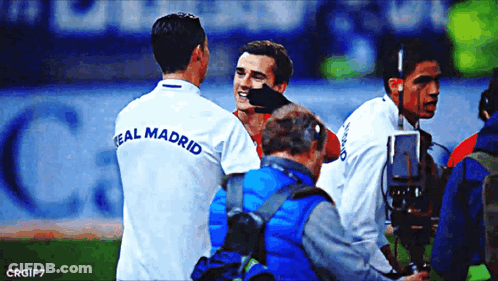 A Soccer Player Wearing A Real Madrid Shirt Talks To Another Player GIF