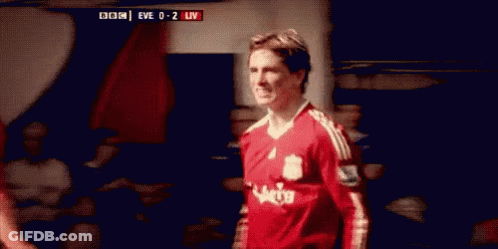 A Soccer Player Wearing A Red Jersey Is Standing In A Locker Room . GIF