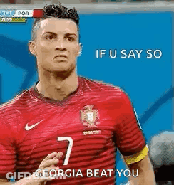 A Soccer Player Wearing A Red Jersey Is Standing On A Field And Saying `` If U Say So Georgia Beat You '' . GIF