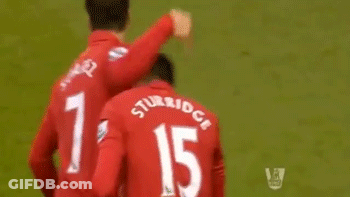 A Soccer Player Wearing A Red Jersey That Says Standard Chartered Is Giving Another Player A High Five GIF