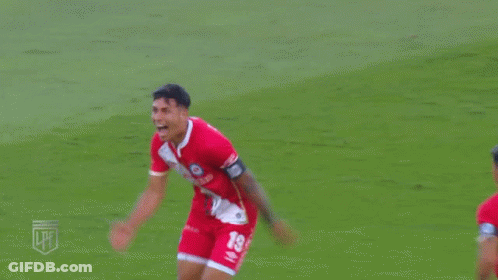 A Soccer Player Wearing A Red Jersey With The Number 19 On It Is Celebrating A Goal GIF