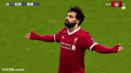 A Soccer Player Wearing A Red Jersey With The Word Standard Chartered On It Is Celebrating A Goal . GIF