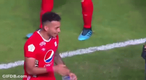 A Soccer Player Wearing A Red Pepsi Shirt Is Holding A Bottle Of Water In His Hand . GIF
