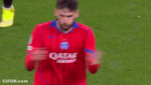 A Soccer Player Wearing A Red Qatar Airways Jersey Is Standing On A Soccer Field . GIF