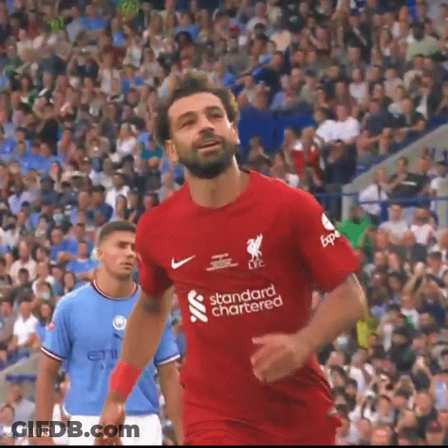 A Soccer Player Wearing A Red Shirt That Says Standard Chartered Is Running On The Field . GIF