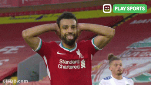 A Soccer Player Wearing A Red Shirt That Says Standard Chartered Sticking His Tongue Out GIF