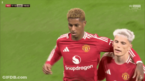 A Soccer Player Wearing A Red Snapdragon Jersey Holds His Finger To His Ear GIF