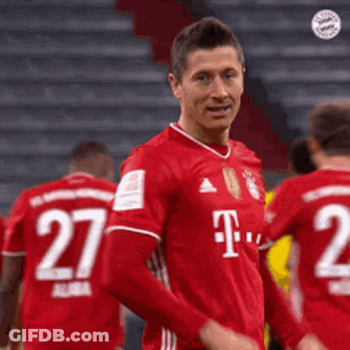 A Soccer Player Wearing A Red T-Mobile Jersey Is Standing In Front Of His Teammates . GIF