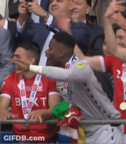 A Soccer Player Wearing A Sky Sports Shirt Stands In The Crowd GIF