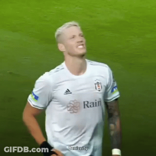 A Soccer Player Wearing A White Adidas Shirt Is Standing On A Field . GIF