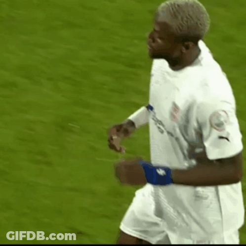 A Soccer Player Wearing A White Jersey And Blue Wristband Is Running On The Field . GIF