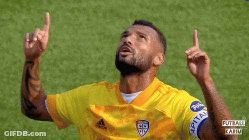A Soccer Player Wearing A Yellow Adidas Jersey Points Up GIF