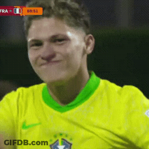 A Soccer Player Wearing A Yellow And Green Shirt Is Smiling . GIF