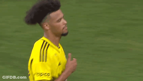 A Soccer Player Wearing A Yellow Jersey Is Standing On A Field . GIF
