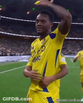 A Soccer Player Wearing A Yellow Jersey With A Blue Stripe On The Sleeves GIF