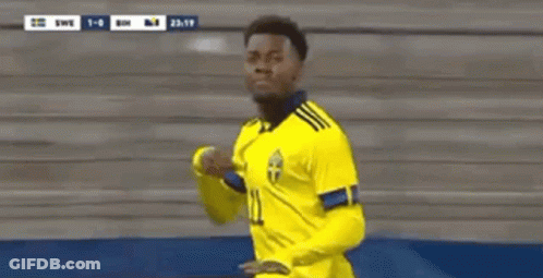 A Soccer Player Wearing A Yellow Jersey With The Number 11 On It Is Standing In Front Of A Stadium . GIF