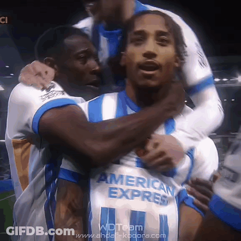 A Soccer Player Wearing An American Express Jersey Is Being Hugged By His Teammates GIF
