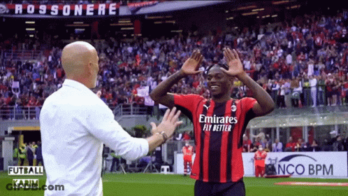 A Soccer Player Wearing An Emirates Fly Better Jersey Talks To A Coach GIF