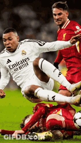 A Soccer Player Wearing An Emirates Fly Better Shirt Is Being Tackled By Another Player GIF
