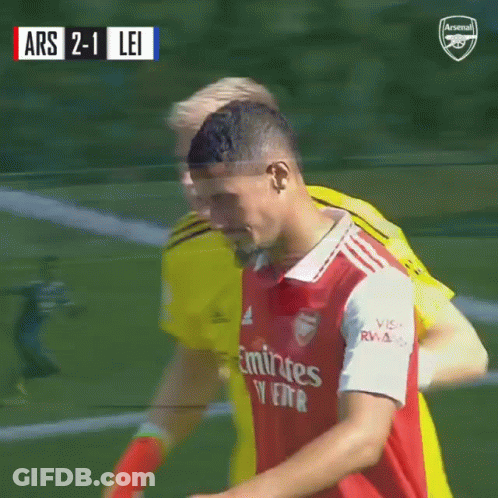A Soccer Player Wearing An Emirates Jersey Is Hugging Another Player On The Field GIF