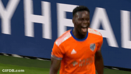 A Soccer Player Wearing An Orange Adidas Jersey Is Celebrating GIF