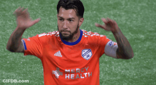 A Soccer Player Wearing An Orange Jersey That Says Mercy Health On It GIF