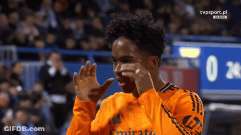 A Soccer Player Wearing An Orange Jersey With Emirates On It GIF